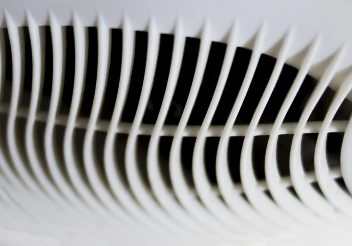 Close-up of white vent slats bending into a wave-like black-and-white pattern